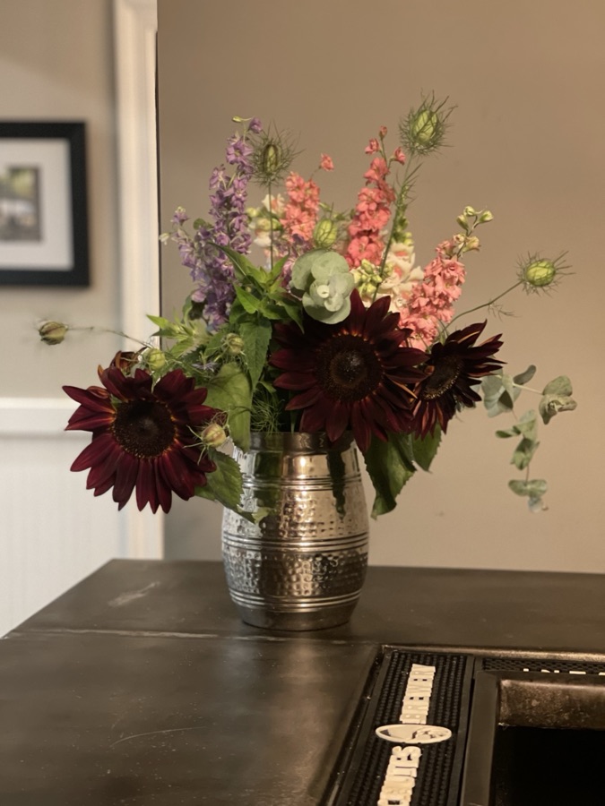 Bouquet of dahlias and wildflowers in a metal vase