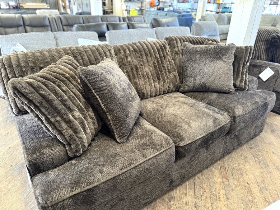 Plush brown sofa with textured pillows in a furniture showroom