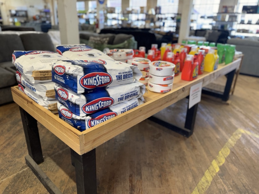 Charcoal and grilling supplies on a store display table