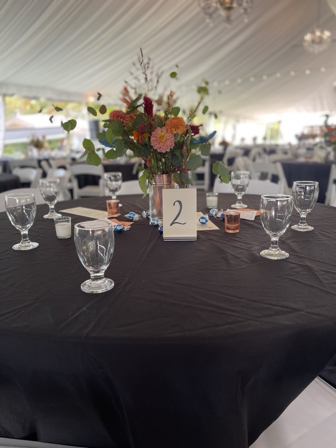 Tent reception table with wildflowers and a table number