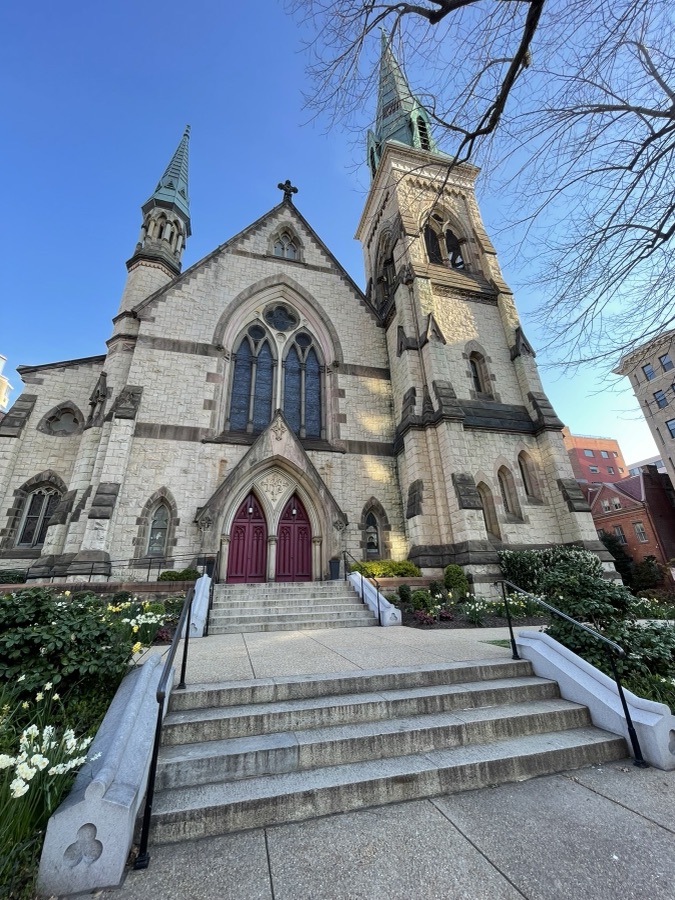 Historic stone church with twin spires and red doors