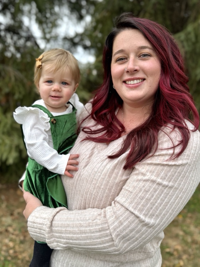 Mother holding her toddler daughter outdoors