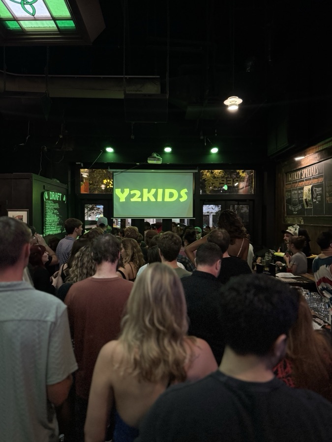 Crowd watching a live show under green stage lights